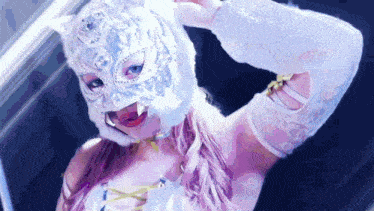 a woman is wearing a cat mask and a white top