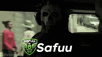 a man wearing a skull mask and headphones is sitting in a car with the word safuu on the bottom .