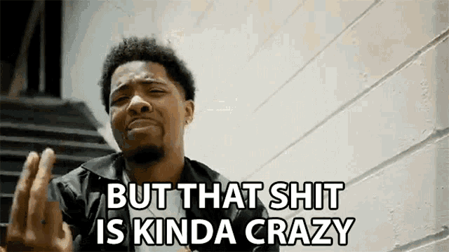 a man is making a funny face and saying `` but that shit is kinda crazy '' while sitting on stairs .