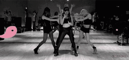 a group of women are dancing on a dance floor in a black and white photo .