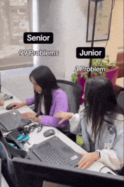 two women sit at a desk with lenovo laptops and one has 99 problems