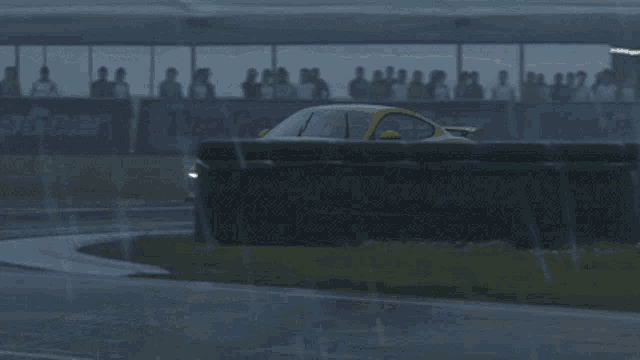 a yellow sports car driving on a wet road