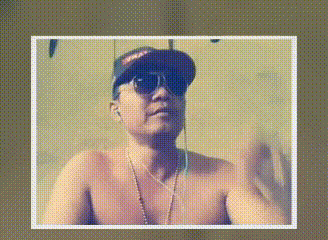 a shirtless man wearing a baseball cap and sunglasses is talking on a video call .