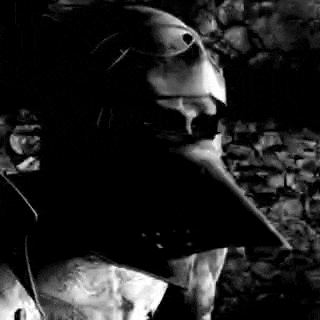 a black and white photo of a knight 's helmet in front of a brick wall .