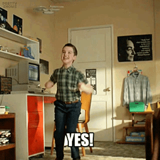 a young boy in a plaid shirt is dancing in a room with the words yes written on the floor