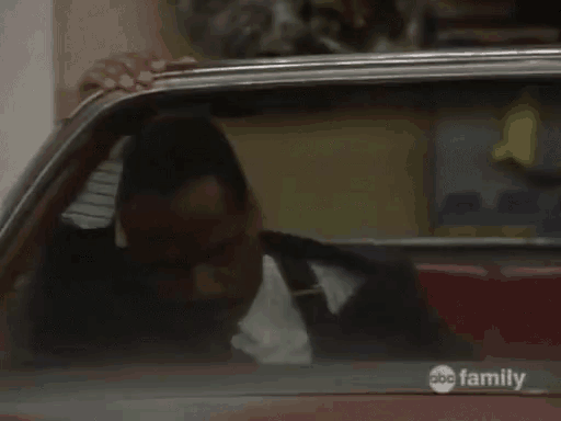 a man is sitting in a car with a abc family logo on the side