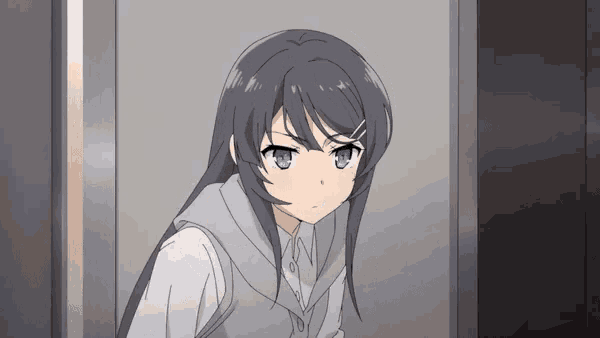 a girl with long black hair is standing in a doorway .