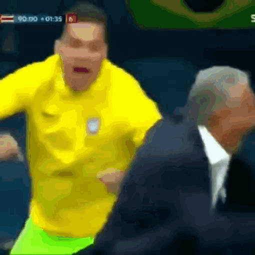 a man in a yellow shirt stands next to a man in a suit