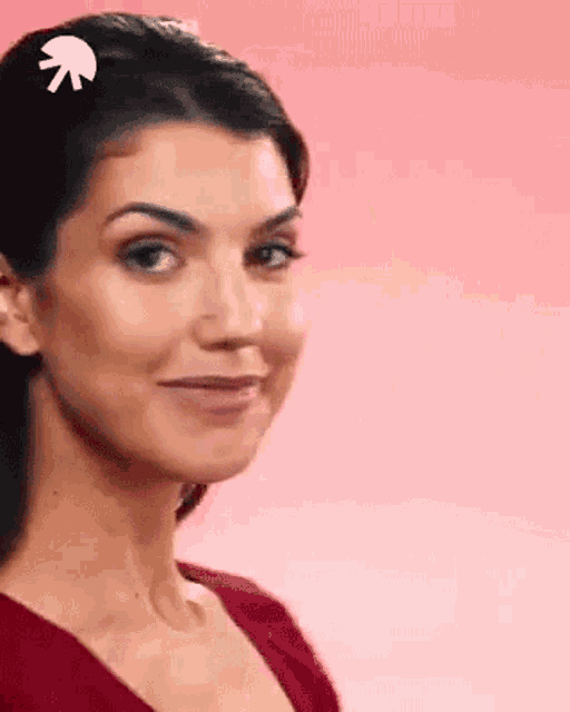 a close up of a woman 's face on a pink background .