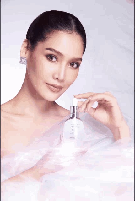 a woman is holding a white bottle that says ' lotion ' on the label
