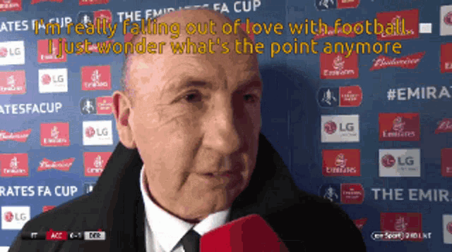 a man in a suit and tie is talking into a microphone while standing in front of a wall with lg logos