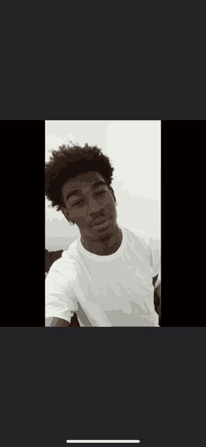 a black and white photo of a young man in a white t-shirt