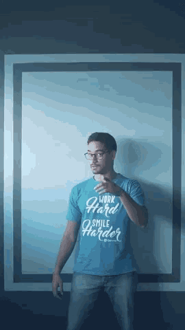 a man wears a blue shirt that says work hard smile harder