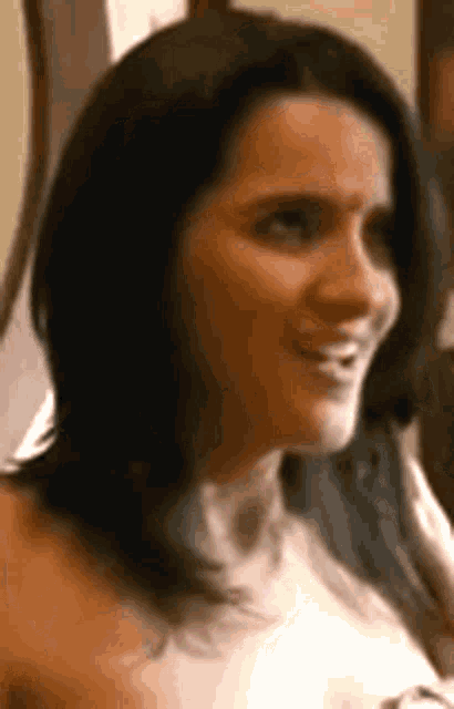 a close up of a woman 's face with long dark hair smiling .