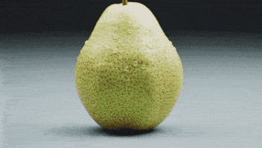 a pear with water drops on it is sitting on a table
