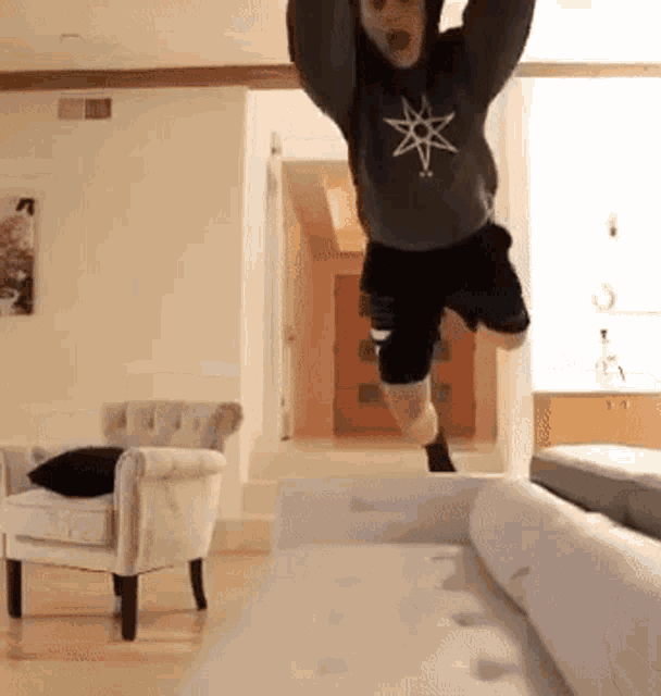 a person is jumping in the air in a living room