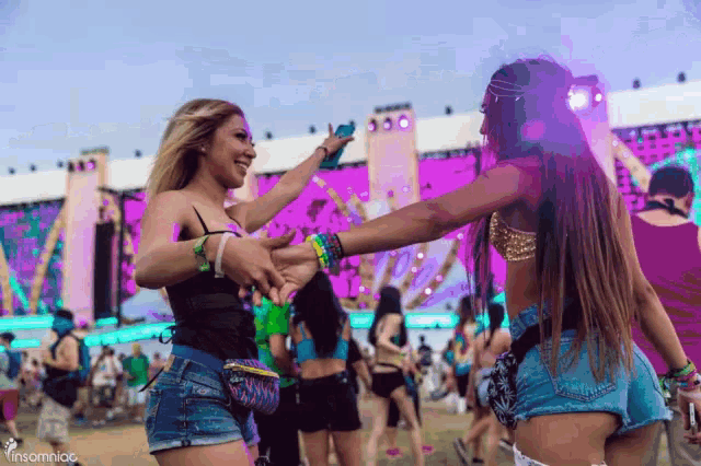 two women are dancing in front of a stage with the words insomniac on the bottom