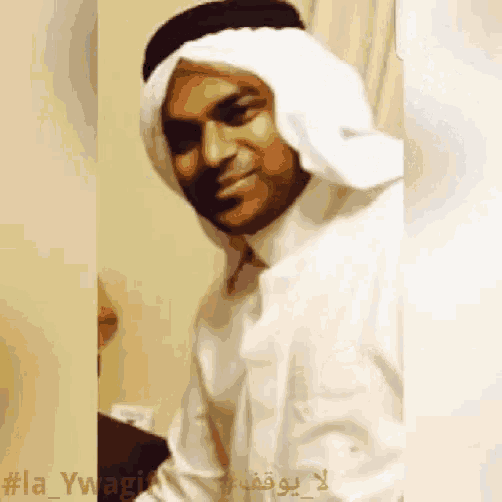 a man wearing a head scarf and a white shirt has the hashtag #la_ywagui on the bottom