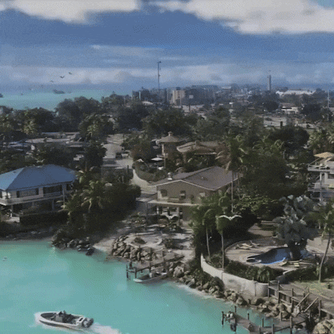 an aerial view of a residential area with a boat floating on the water