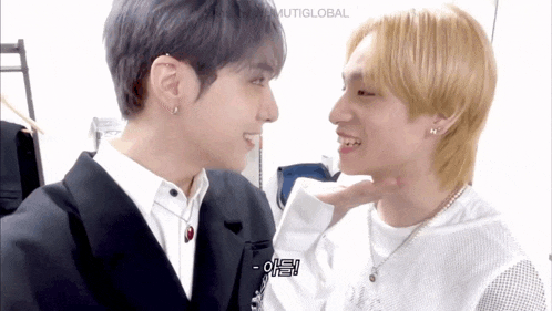 two young men are looking at each other and one of them has a bite taken out of his neck .