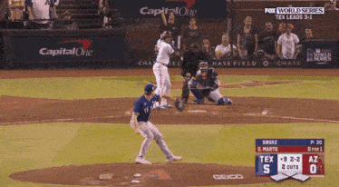 a baseball game is being played in front of a capital one sign