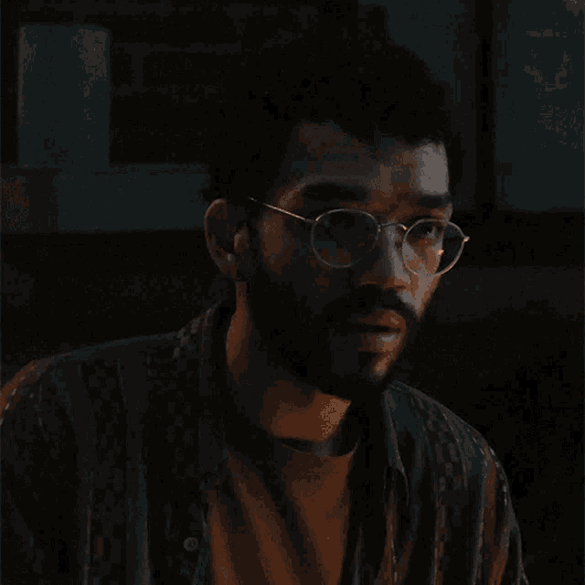 a man with a beard wearing glasses and a floral shirt