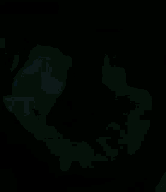 a person in a blue jacket is holding another person 's arm in a dark room .