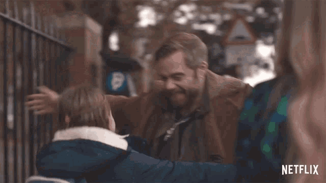 a man is hugging a little girl in a scene from netflix .