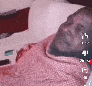 a man laying in a bed with a thumbs up and dislike icons