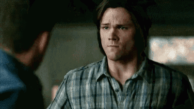 a man in a plaid shirt is standing next to another man .