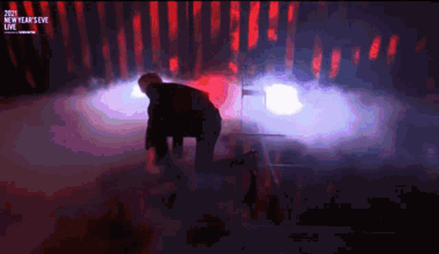 a man is kneeling on a stage at a new year 's eve live event