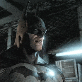 a close up of a man in a batman costume talking to a police officer .