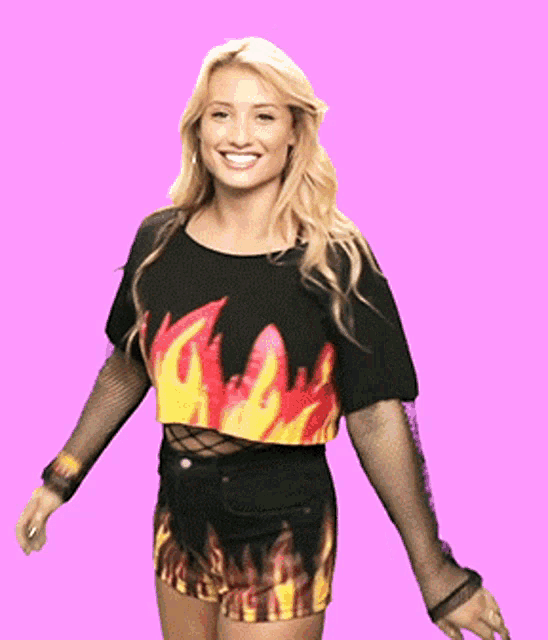 a woman wearing a crop top with flames on it is smiling