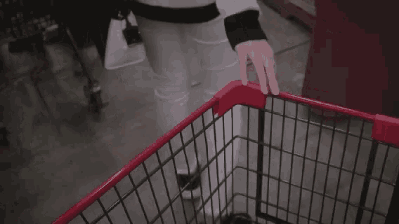 a woman is pushing a shopping cart in a store