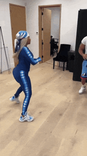 a woman in a blue outfit is dancing with a man