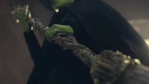 a person with green paint on their arms is holding a sword