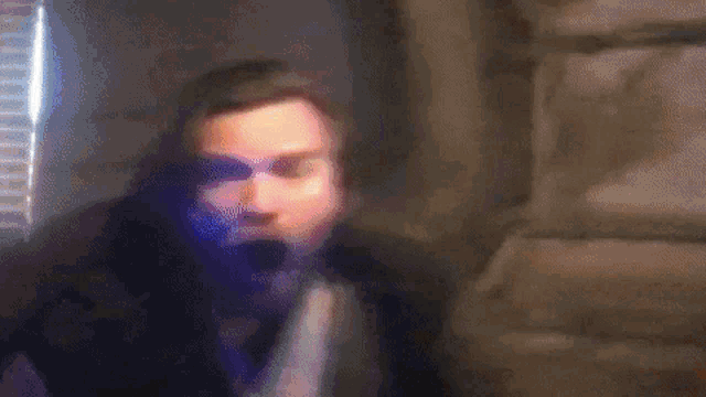 a blurry picture of a person 's face with a red light behind them .
