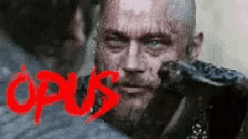 a close up of a man with the word opus in red