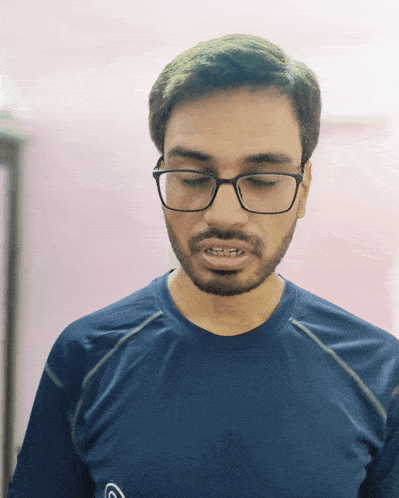 a man wearing glasses and a blue shirt with the letter g on the front