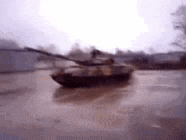 a blurred image of a tank driving on a road .
