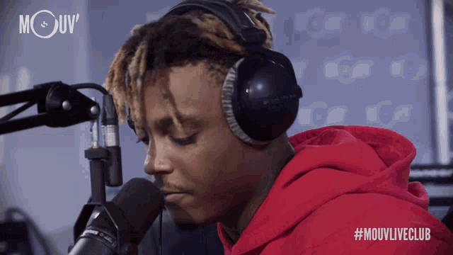 a man wearing headphones and a red hoodie stands in front of a microphone with the hashtag #mouvliveclub