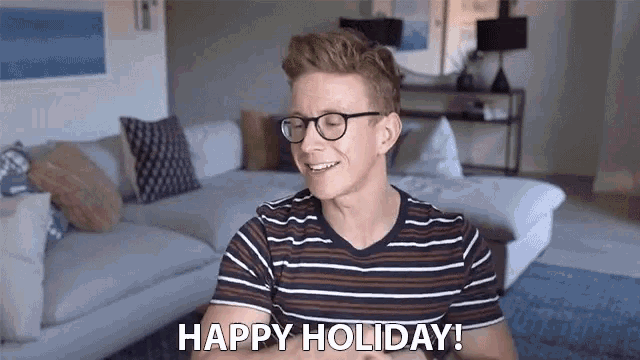 a man wearing glasses and a striped shirt says " happy holiday "