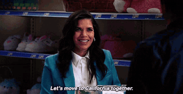 a woman in a blue suit says let 's move to california together while talking to a man