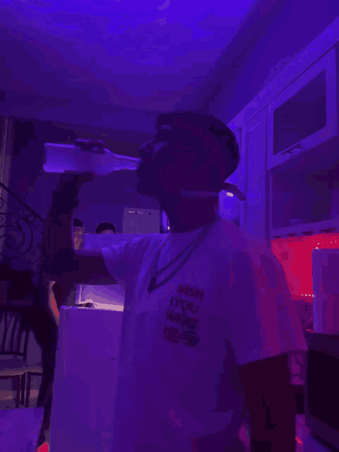 a man wearing a shirt that says wish you were here is drinking from a bottle