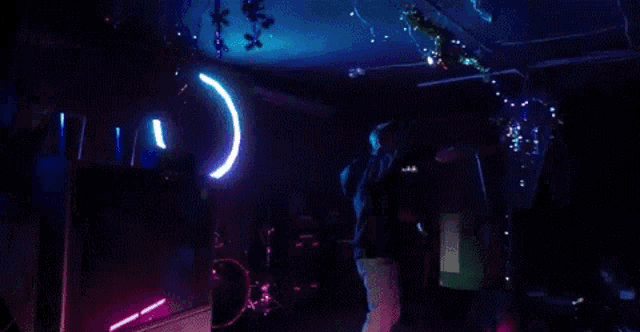 a man is standing on a stage holding a microphone in front of a circle of light .