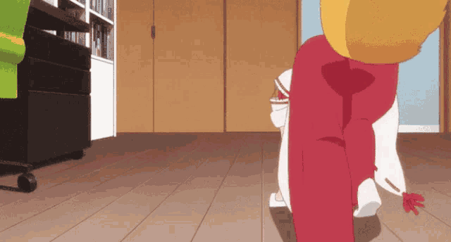 a person in red pants is walking on a wood floor