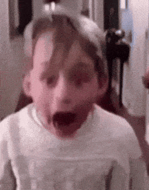 a close up of a child 's face with his mouth open .