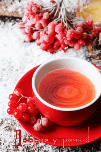 a red cup of tea sits on a red saucer next to a bunch of red berries and the words доброе утрочко