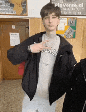 a young man wearing a black jacket and a t-shirt that says brooklyn is standing in a hallway .