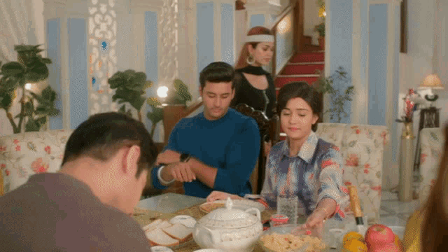 a group of people sitting around a table with food and drinks